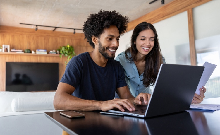 Casal de empreendedores conferindo os impostos da empresa no notebook